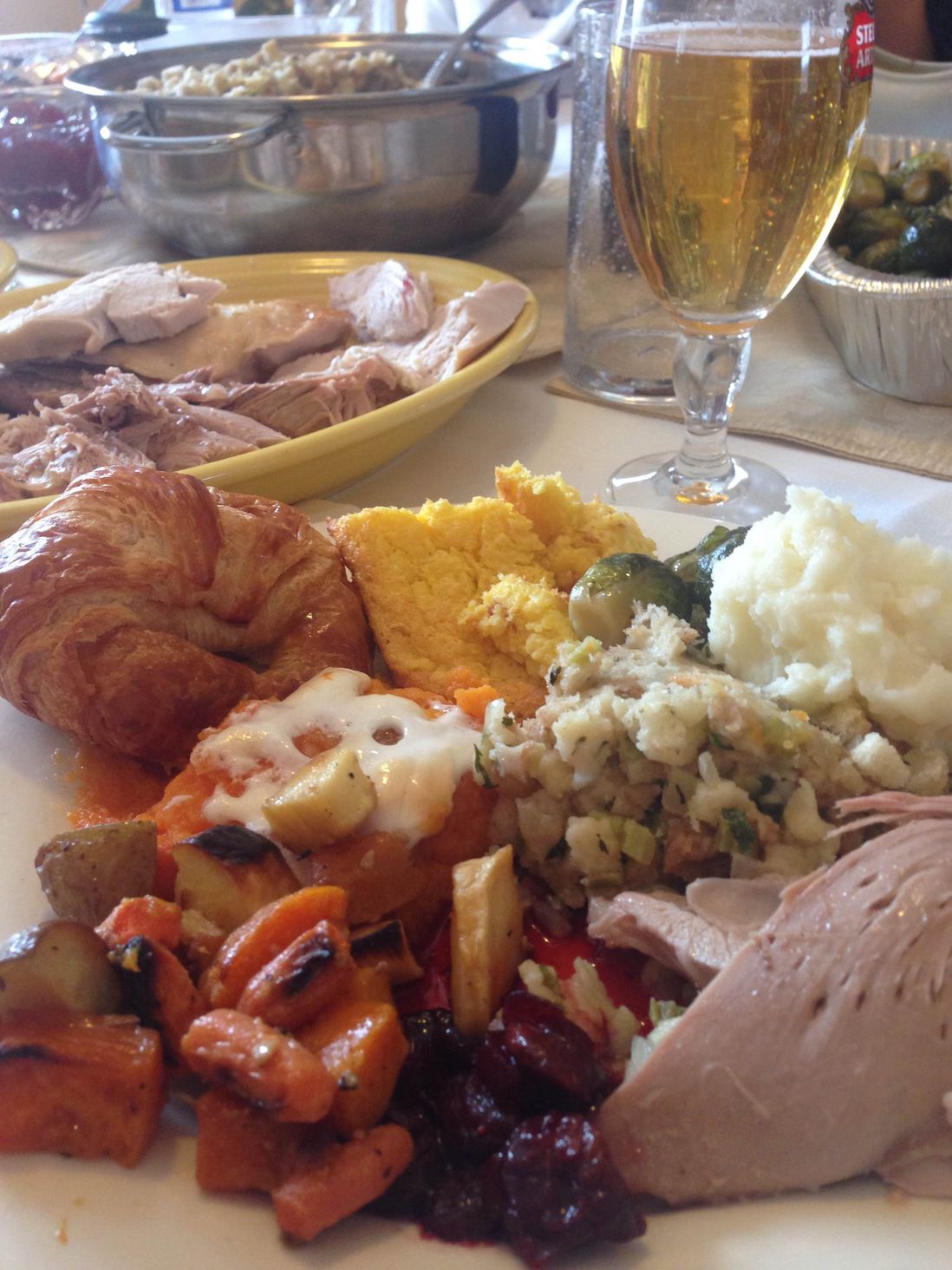 What we have here is corn pudding, maple Brussels sprouts, roasted root vegetables, candied yams, mashed potatoes, cranberry cherry compote, a croissant, Grandma Janet's famous stuffing and a slice of bird (for photo purposes only) as well as a chalice of Stella (not a glass). - Morgan Walters
